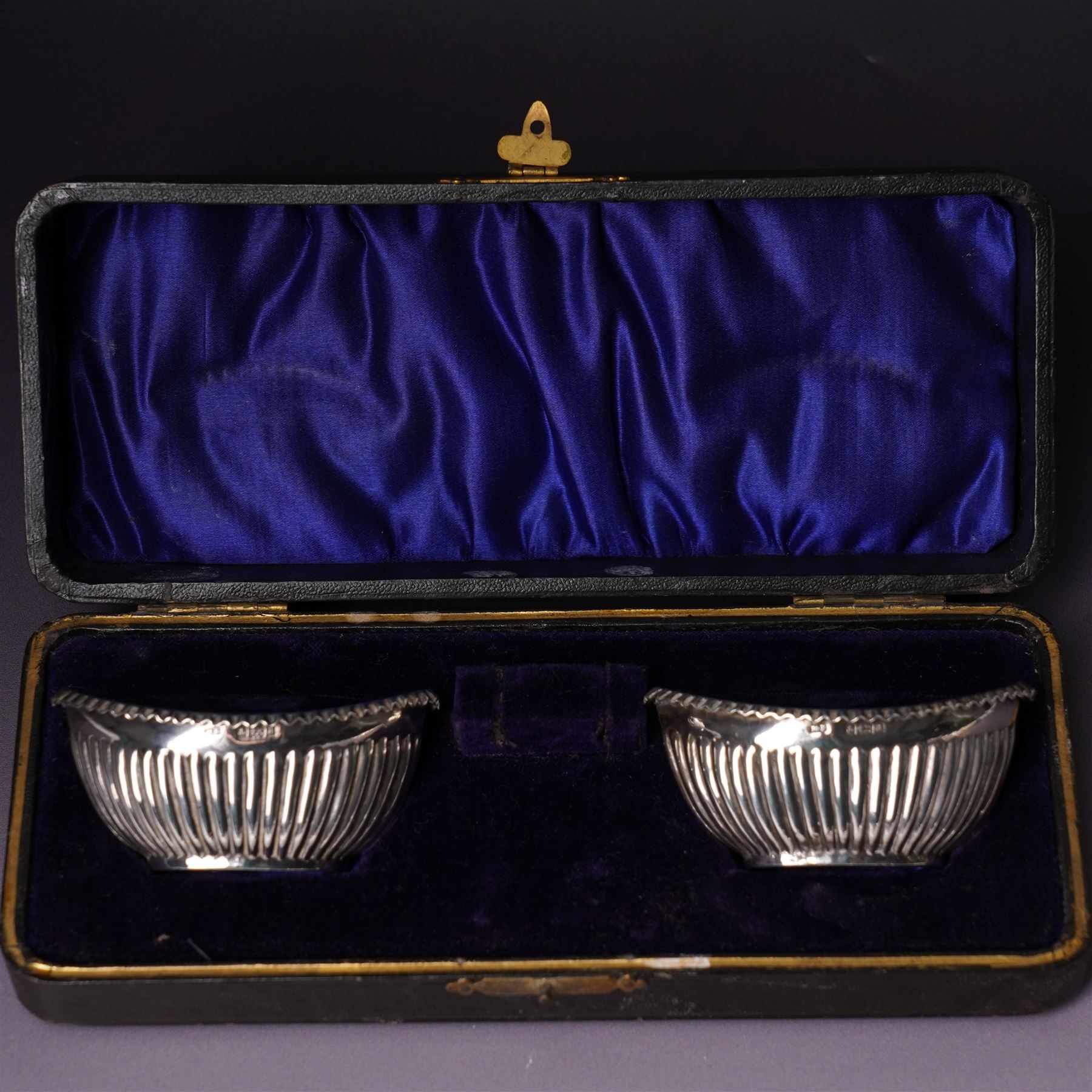 Pair of silver navette shape salts , cased Birmingham 1900 Maker Mitchell Bosley & Co., silver three piece condiment set, pair of silver cornucopia shape salts, silver upright photograph frame 17cm x 13cm and a pair of glass salts with silver rims