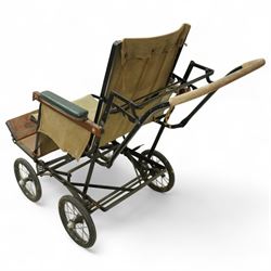 *Early 20th century invalid chair, the tubular metal frame with folding mechanism, canvas seat and back, padded armrests, raised on coil springs and large spoked wheels with wooden footrestFrom the Kirkham Hall Attic & Cellar Collection, sold without reserve