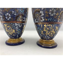 Edwardian pair of Doulton Lambeth stoneware vases, the bodies of baluster form with typical floral and foliate decoration upon merging blue and white ground with copper banding, and flared foliate neck decorated with acanthus leaf detail, decorated with gilt throughout, impressed marks c 1902-1922, and painted marks X 3904, H32cm