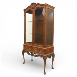 Queen Anne design walnut display cabinet, carved cartouche above two glazed doors enclosing two fixed glass shelves, over two frieze drawers above a heavily carved apron with cabriole supports