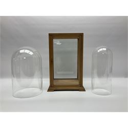 Tabletop glass display cabinet, with hinged door, together with two glass domes