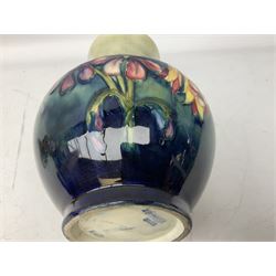 Moorcroft vase of baluster form decorated in the Spring Flowers pattern upon a merging green and blue ground, with impressed and painted marks beneath, H22.5cm