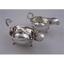 Pair of modern silver sauce boats, of typical plain form, each with oblique gadrooned rims and chevron capped flying scroll handles, upon three hoof feet, hallmarked Charles S Green & Co Ltd, Birmingham 1961