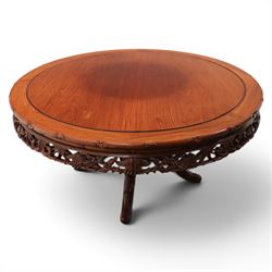 20th century Chinese ornately hardwood dining table and chairs, circular table with 'Lazy Susan' top with pierced carved frieze, raised on a quadriform base with carved foliate detail, the chairs en suite with carved pierced detailing  
