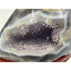 Amethyst crystal geode cluster, with well-defined crystals of various sizes, upon a carved wooden stand, H12cm, L20cm
