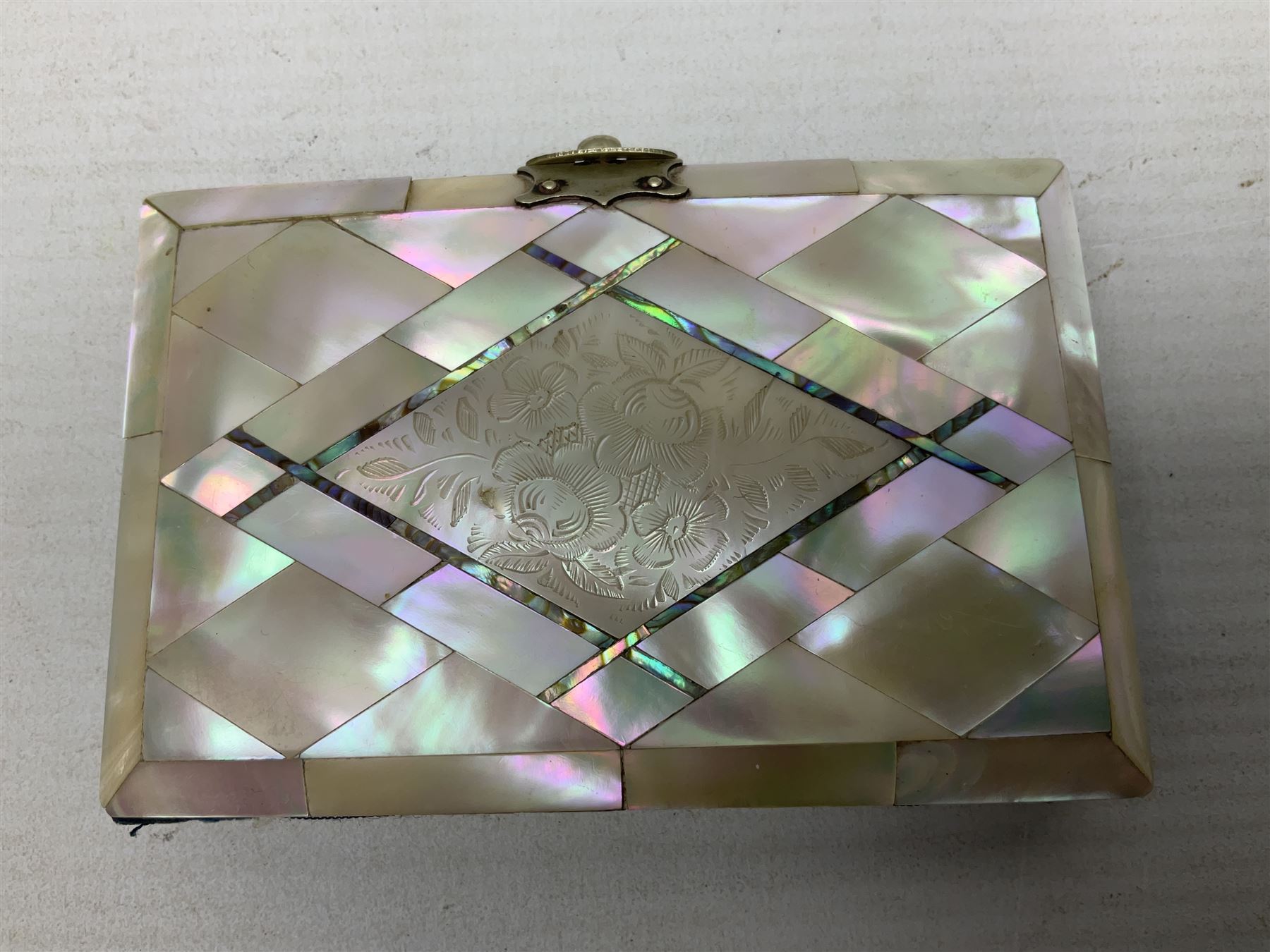 Mother of pearl and abalone inlaid card case, with central diamond shaped panel engraved with foliate decoration, together with a simulated mother of pearl card case of book form with green sun rays to cover, and simulated wood effect cigarette case with hinged lid with diamante style banding, largest L10cm