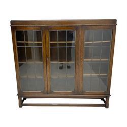 Early 20th century oak bookcase, fitted with three lead glazed doors