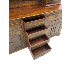 Traditional oak dresser, the moulded cornice over shaped apron, three heights plate rack fitted with two cupboards, the base fitted with six drawers and two double cupboards, panelled pointed ogee arched doors, on bracket feet