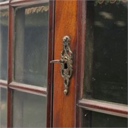 Late 19th century Continental bombe cabinet on chest, shaped moulded cornice with carved cresting, the upper section enclosed by a pair of arched glazed doors with astragal glazing revealing a shelved interior, the lower section fitted with four graduating drawers with rococo-style metal handles, serpentine front and sides, raised on scroll and paw feet
