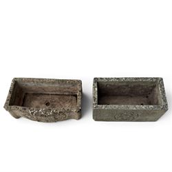 Two weathered composite stone garden trough planters, comprising a low serpentine trough relief moulded with rocaille, shell and foliate ornament (W55cm D32cm H19cm); the plain rectangular trough decorated with four moulded Yorkshire rose medallions to each side (W51cm D26cm H25cm)