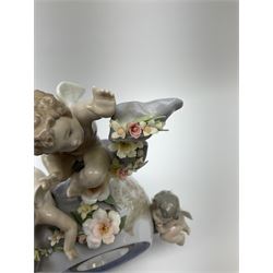 A Lladro mantel clock modelled as a globe with inset clock, surmounted by four putti and floral garlands, with blue printed mark and impressed 5973 beneath, H29cm.