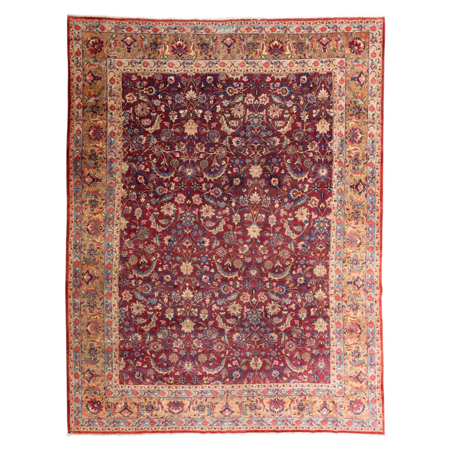 North East Persian Meshed hand-knotted carpet, rich red all-over field of finely decorated with dense scrolling floral sprays and palmettes and flowering vines, enclosed by a broad border in soft pastel tones, flanked by multiple guard borders, with cotton fringe ends  