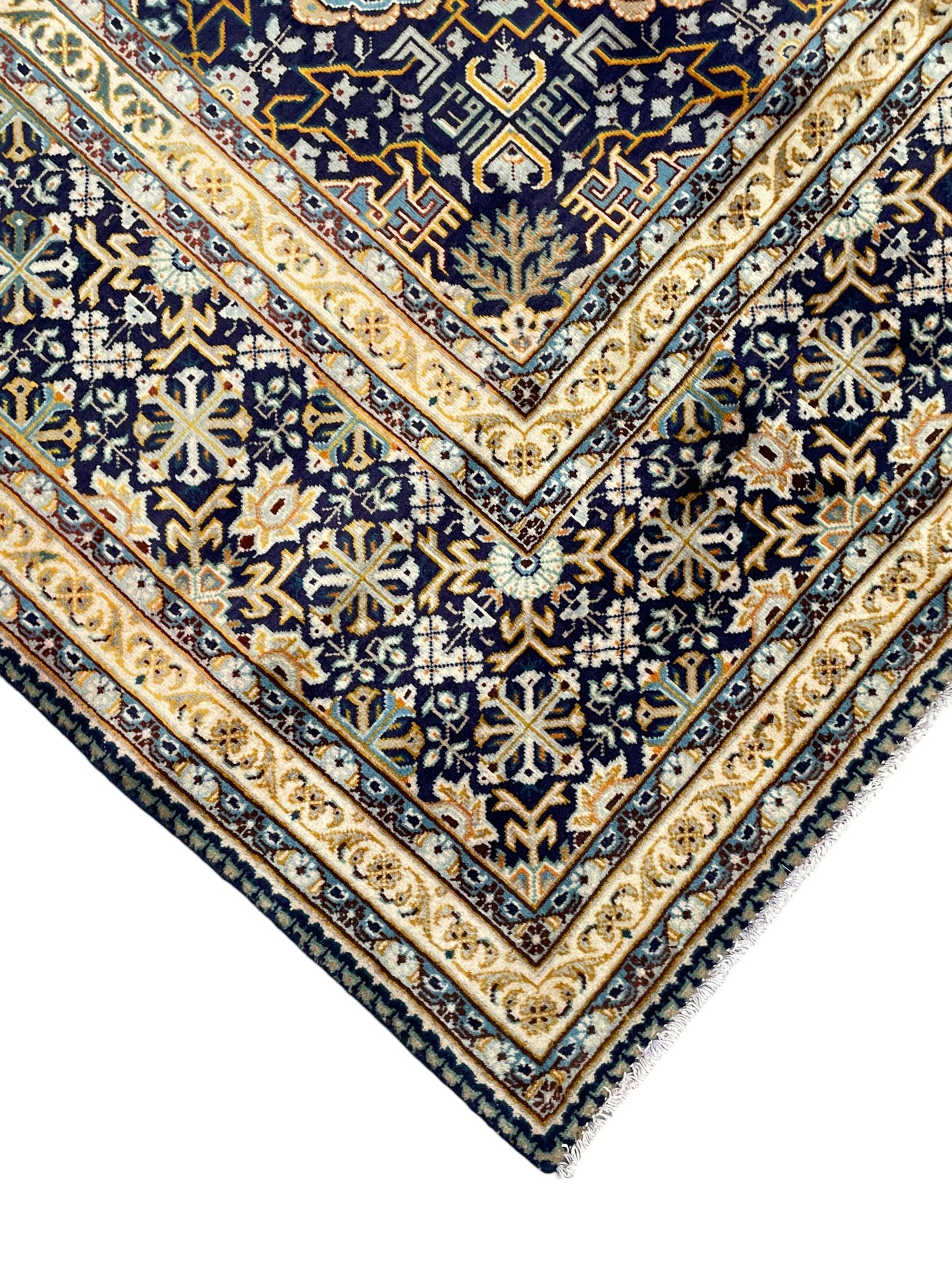 Persian indigo and pale gold ground rug, overall busy geometric design, the field decorated with hooked Hac and palmette medallions surrounded by densely patterned zig-zags and stylised foliate motifs, the border decorated with smaller Hac motifs, within multiple guard stripes 
