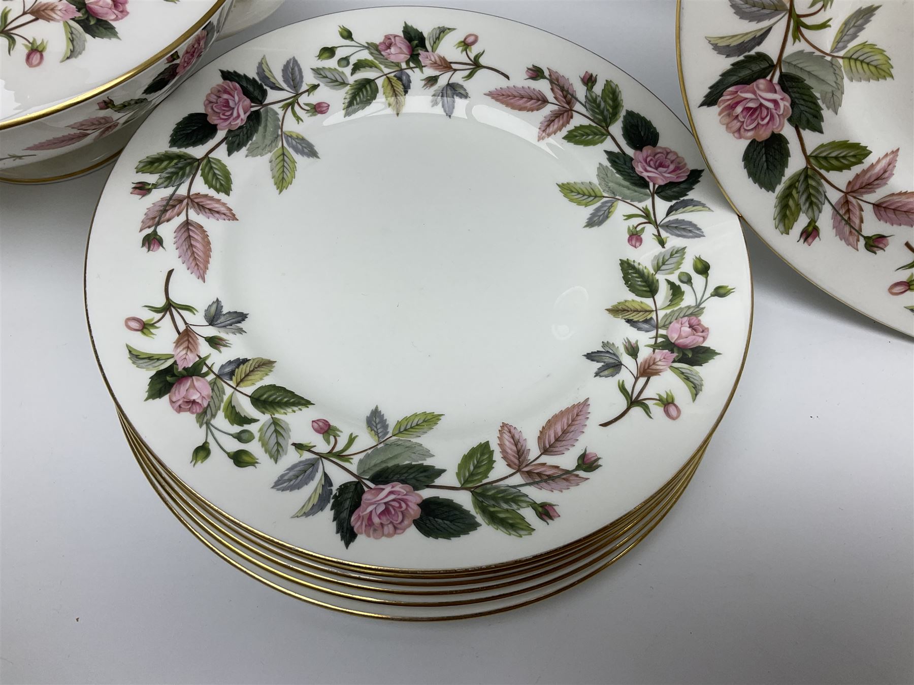 Wedgwood Hathaway Rose pattern tea and dinner wares, comprising twelve saucers, sixteen teacups, twenty tea plates, jug, sucrier, thirteen shallow bowls, sauce boat and saucer, two lidded tureens, larger jug, ten dinner plates, nine smaller plates and two large oval serving dishes