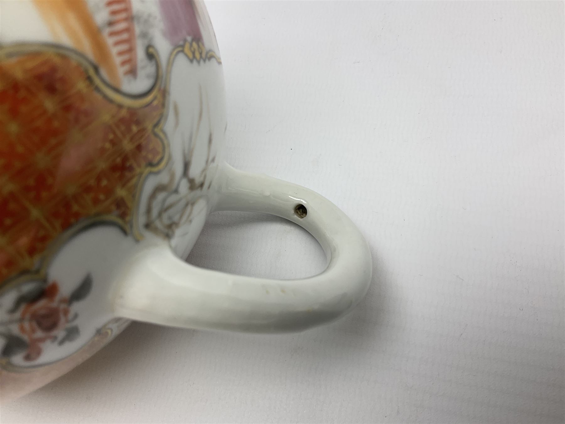 Two late 18th/early 19th century Chinese export teapots, the largest example of globular form with curved handle and straight spout, decorated in the Mandarin style with figural scenes surrounded by red scale reserves, H13.5cm, the second smaller example decorated in underglaze blue with two musicians in a landscape set with willow tree and fence, H10.5cm

