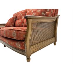 Ercol medium elm framed three seat bergere sofa, and pair of matching armchairs upholstered in red fabric