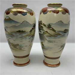 Pair of Japanese Meiji period Satsuma vases, decorated with scenes of procession within a mountainscape, with signature beneath, H25cm