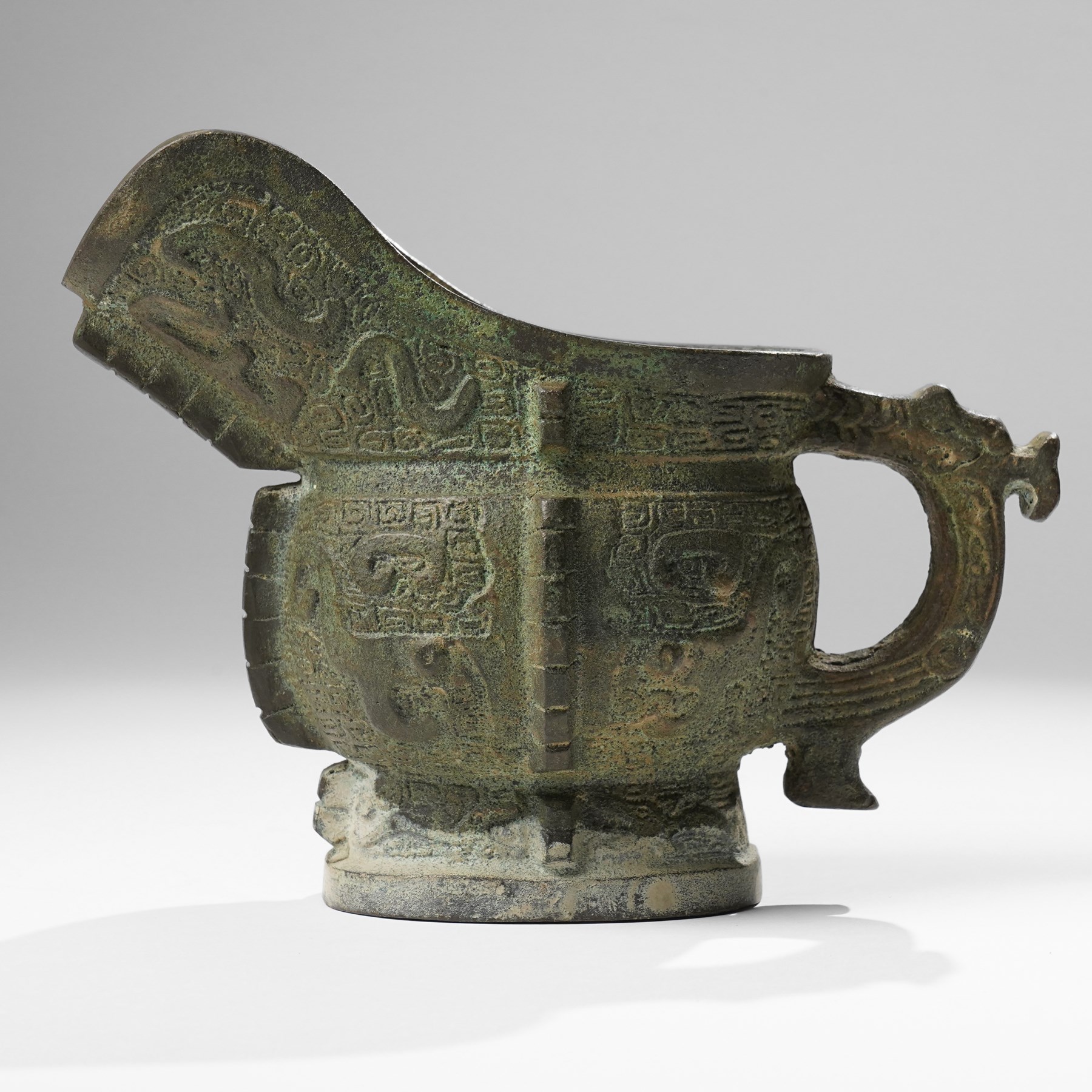 Chinese archaistic bronze wine vessel, Shang dynasty style but 20th century, W25cm; together with a Tang dynasty style model of a rearing horse, H17.5cm (2)