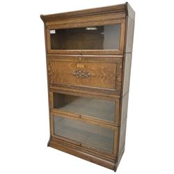 Globe Wernicke design - early 20th century oak four-tier stacking library bookcase, three glazed cabinets with up-and-over doors, fall front compartment with fitted interior 