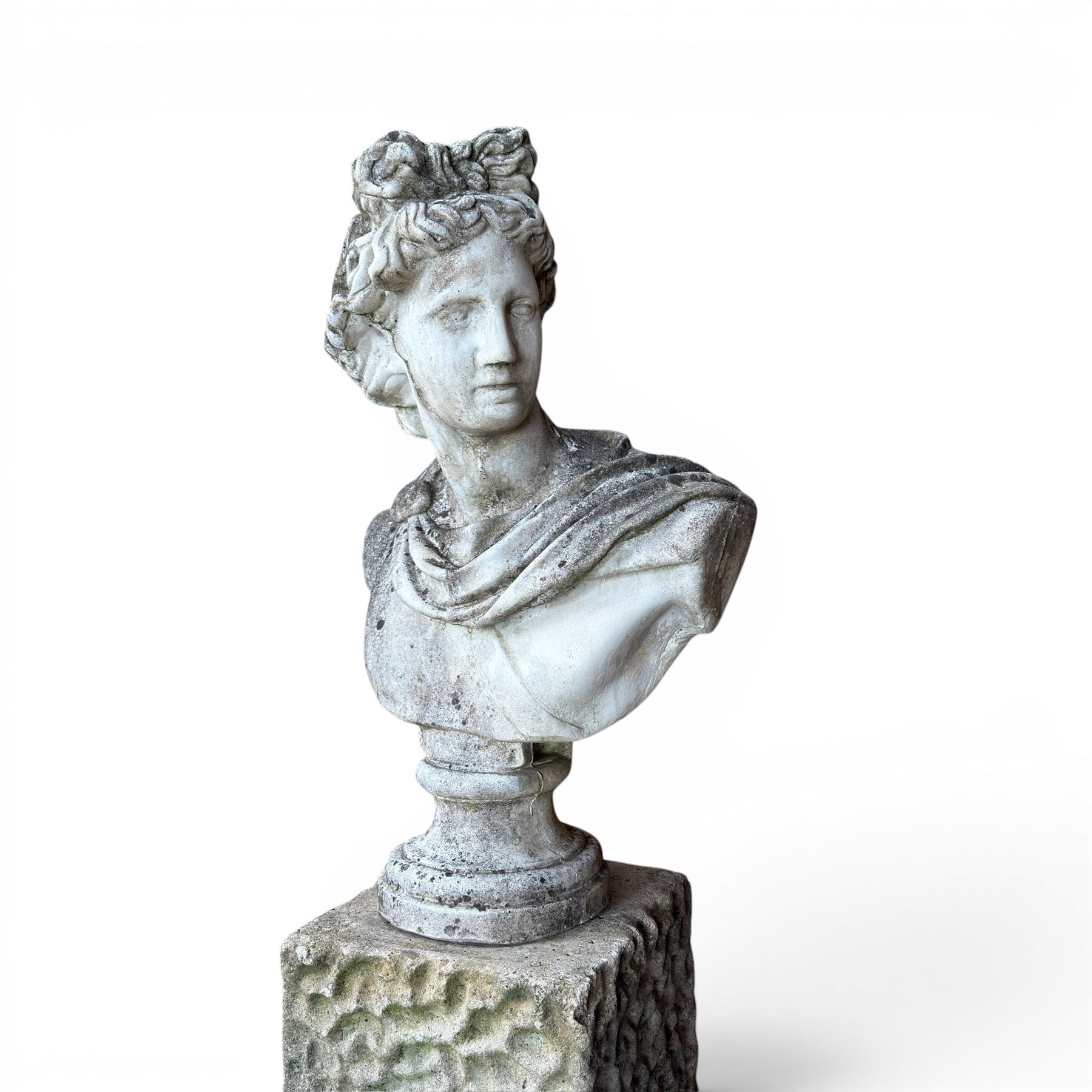 Roman Neoclassical style cast stone bust, weathered finish, raised on textured stone plinth of tapering form