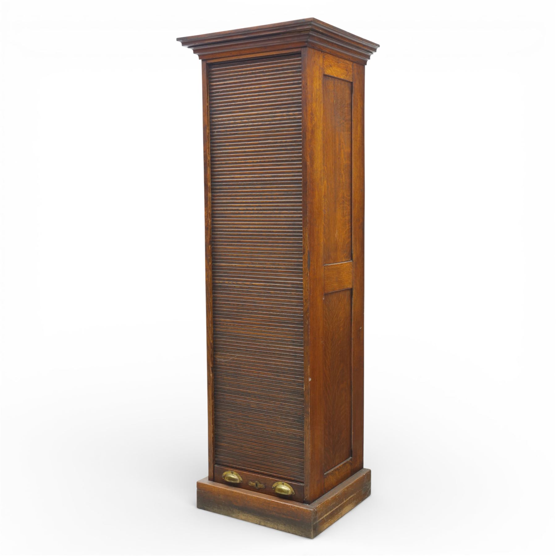 Edwardian oak pedestal office cabinet, moulded rectangular top over tambour shutter enclosing fitted interior, with fifteen graduated drawers each with recessed brass cup handle and label holders, panelled sides, on plinth base