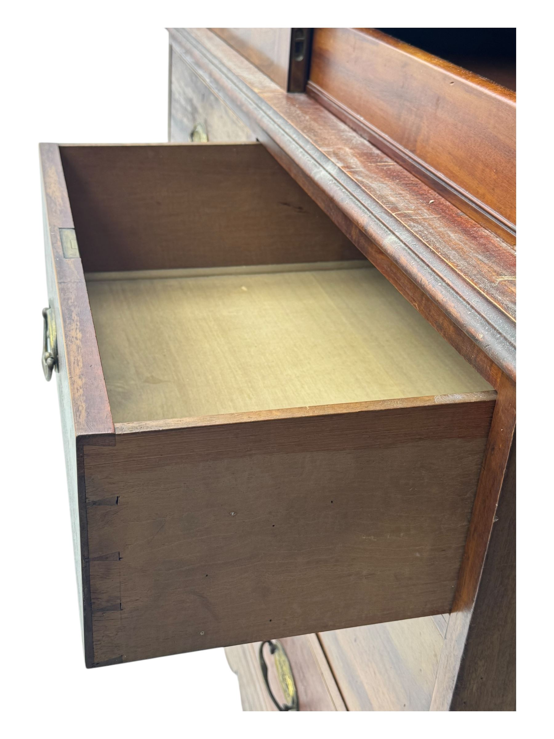 George III mahogany linen press cupboard, projecting moulded cornice over two panelled doors, the interior fitted with two slides and shelf, two short and two long drawers below, shaped apron over bracket feet 