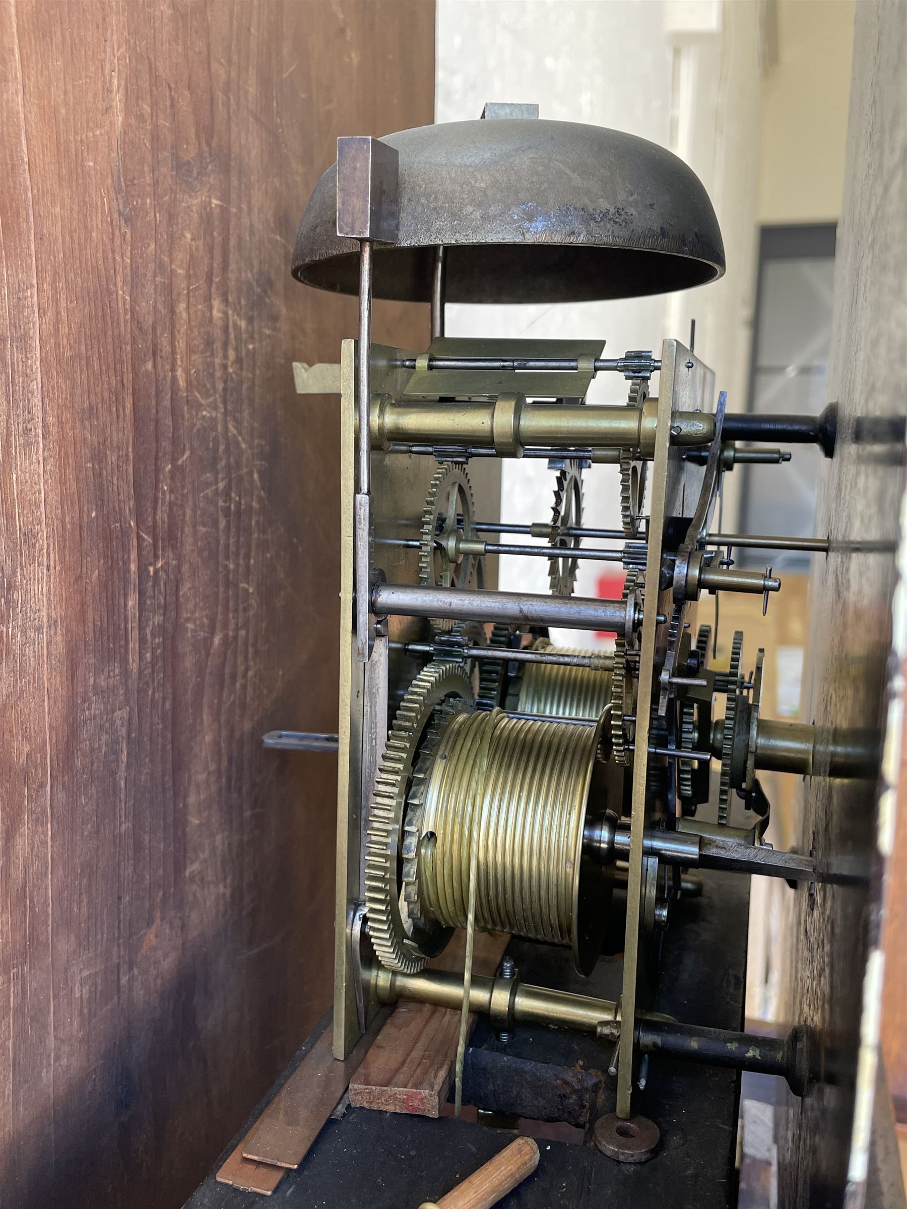 An oak and mahogany longcase clock by William Hewson, Lincoln c 1860, with a swans neck pediment, ball and spire finials and brass paterae, break arch hood door flanked by reeded pilasters with brass capitals, oak trunk with canted corners and a short oak door with mahogany crossbanding, conforming plinth with applied skirting, fully painted dial with Roman numerals, minute track and subsidiary seconds dial, matching brass stamped hands and winding collets, depiction of a  sportsman to the break arch and corresponding game birds to the spandrels, dial pinned directly to an eight-day rack striking movement with a recoil anchor escapement, striking the hours on a bell. Original casemakers label pasted to the inside of the case 
