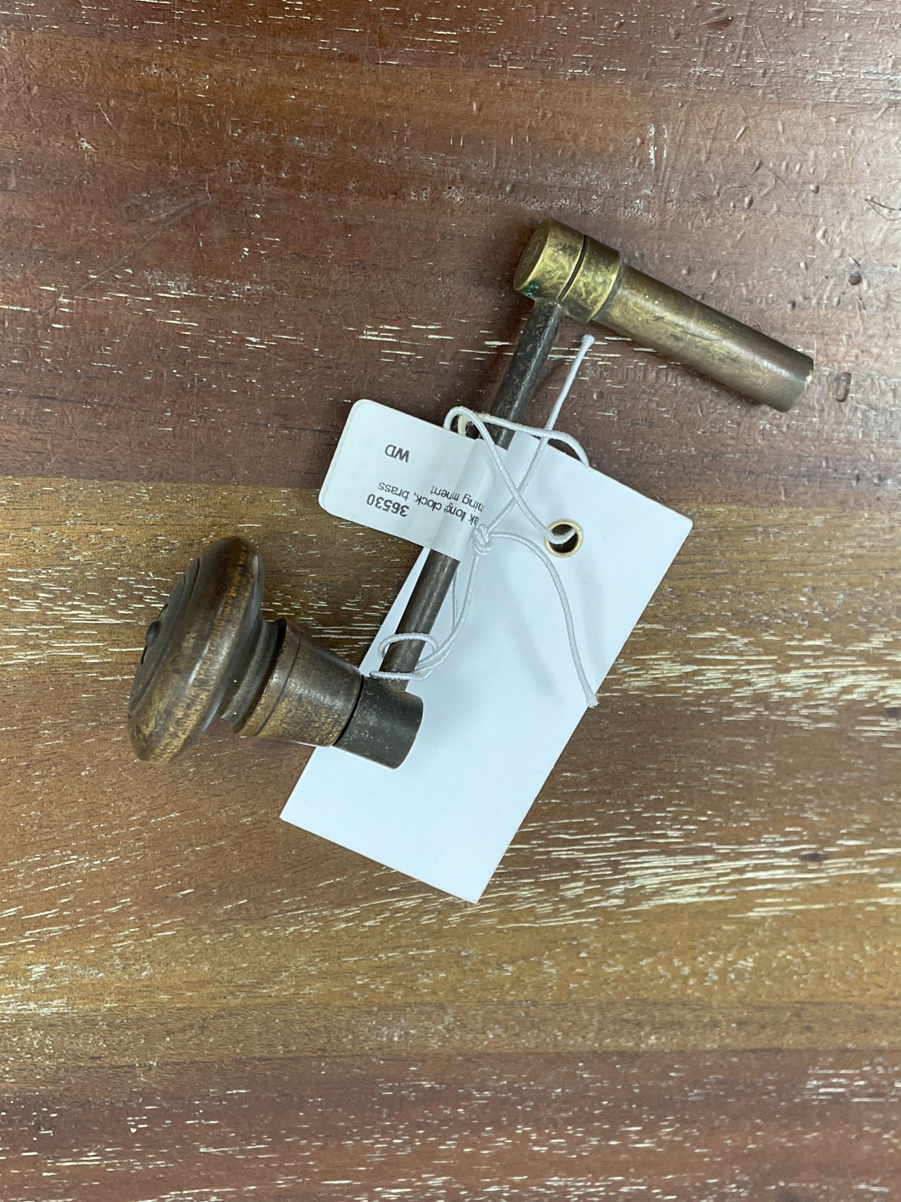 19th century carved oak longcase clock, projecting cornice over guilloche carved frieze, square brass dial with silvered Roman chapter ring and calendar aperture, decorated with ornate mask cast spandrels, the trunk door and base carved with potted plant, twin train driven eight day movement striking on bell