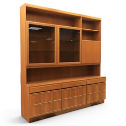 Mid-20th century teak wall display unit, featuring two glazed cupboards and fall front compartment with open shelves, above three drawers and cupboards to the base