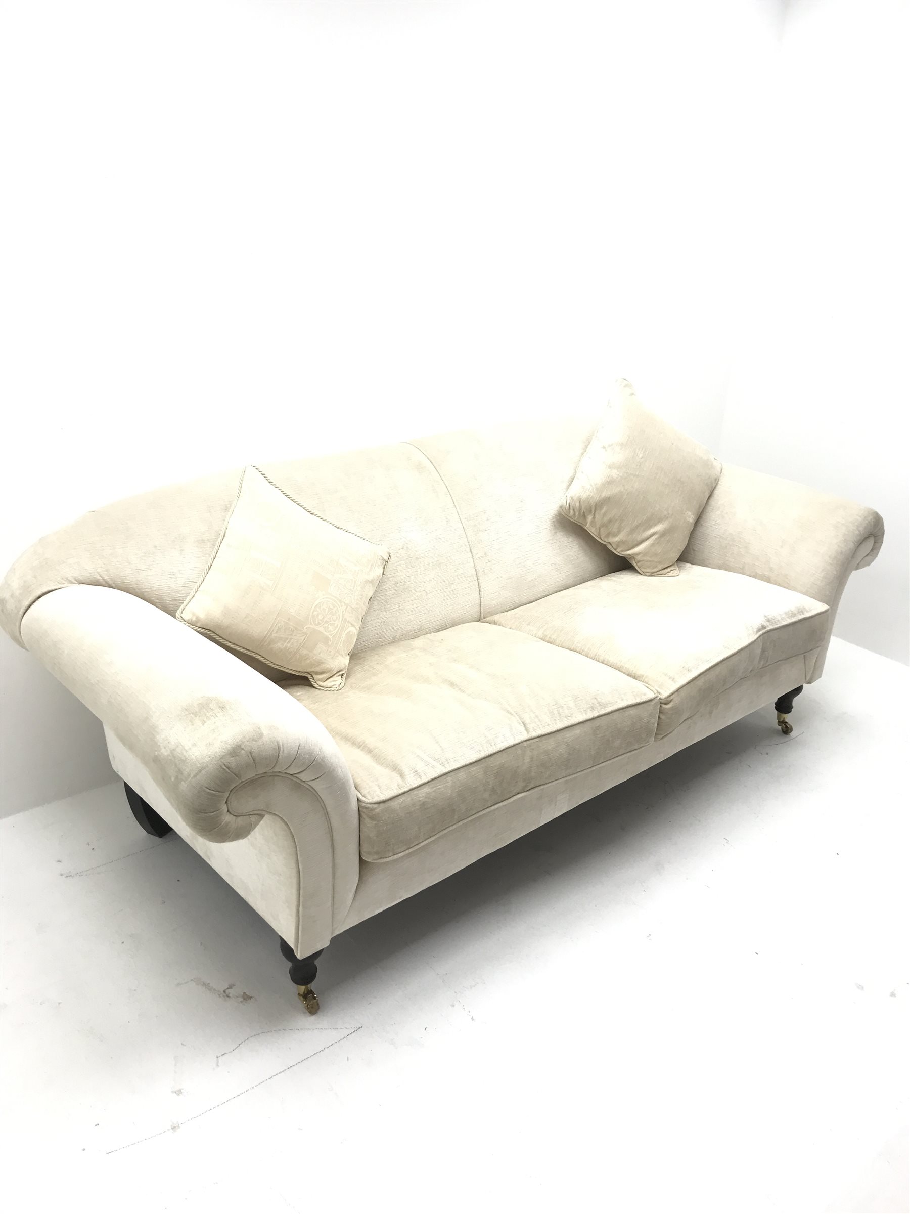 Three seat sofa upholstered in an cream chenille fabric, scrolled arms, turned supports, W220cm