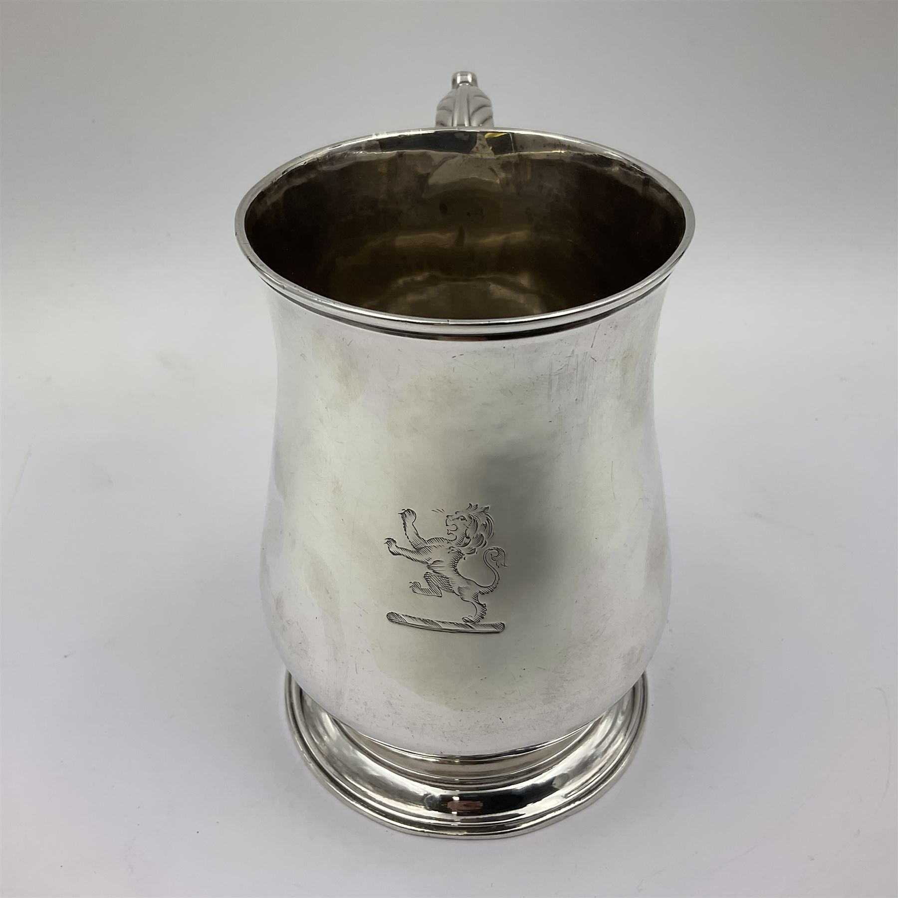 George II silver tankard, of waisted baluster form with acanthus capped C scroll handle, the body engraved with a lion rampant, upon a circular spreading foot, hallmarked Gabriel Sleath & Francis Crump, London 1754, H13cm