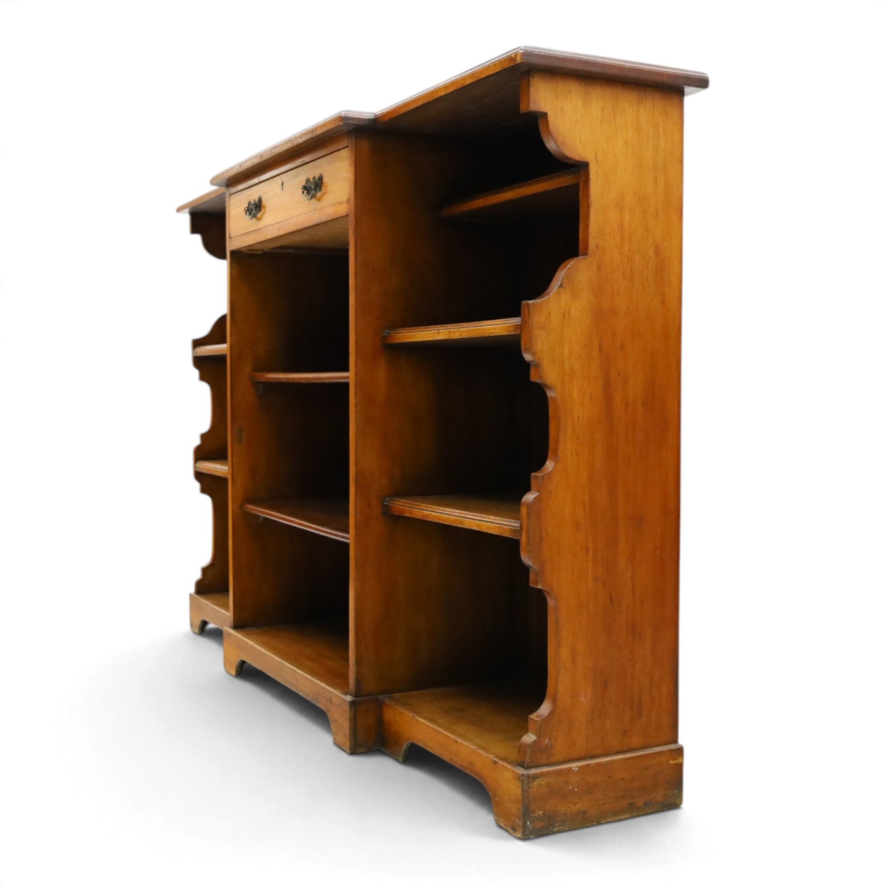 Early 20th century mahogany breakfront open bookcase, the shaped rectangular top with moulded edge, fitted with single frieze drawer over to open shelves, flanked by two shelves to each side with shaped uprights, on bracket feet
