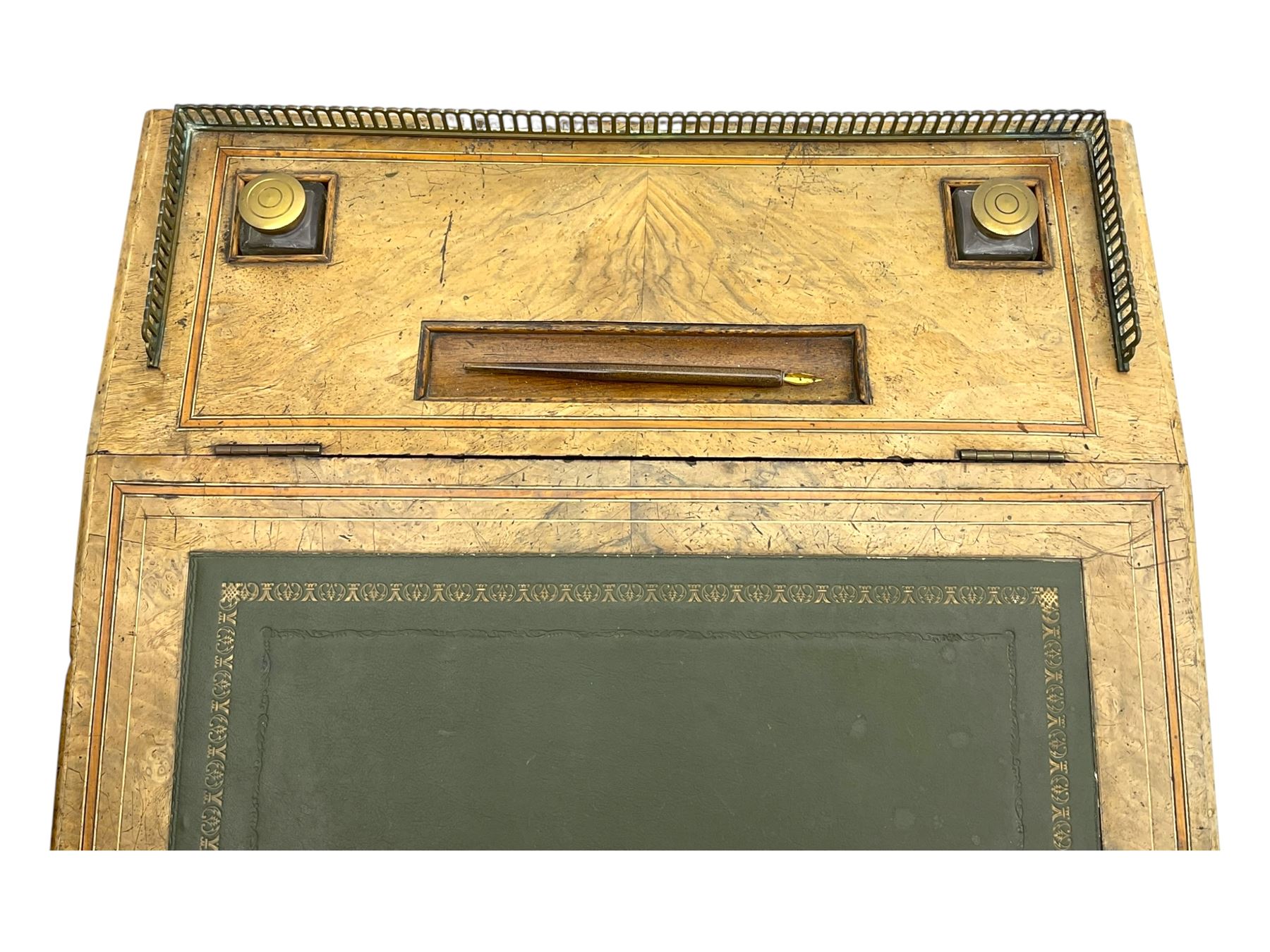 Early 19th century burr walnut Davenport desk, sloped leather-inset writing surface with brass gallery, fitted with an inkwell compartment and pen slot, four drawers to one side, raised on scrolled supports terminating in castors