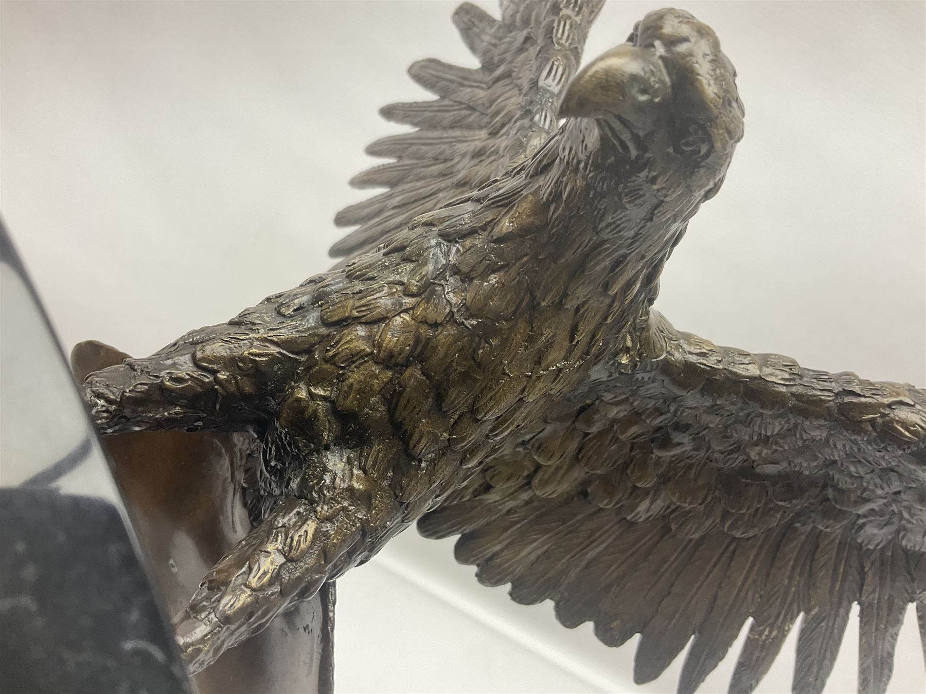 Bronze eagle, modelled in a standing position with wings spread, raised on a black veined marble circular plinth base, H29cm
