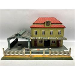 '0' gauge - Bing tin-plate two-storey double sided station with open walk-through to one end, rail side canopy, hinged doors and removable roof giving access to clock illumination L35cm; Bing hand-cranked turntable and open wagon; Marklin tin-plate level crossing barrier and Newspaper vendor's tin-plate four-wheel hand cart (5)
