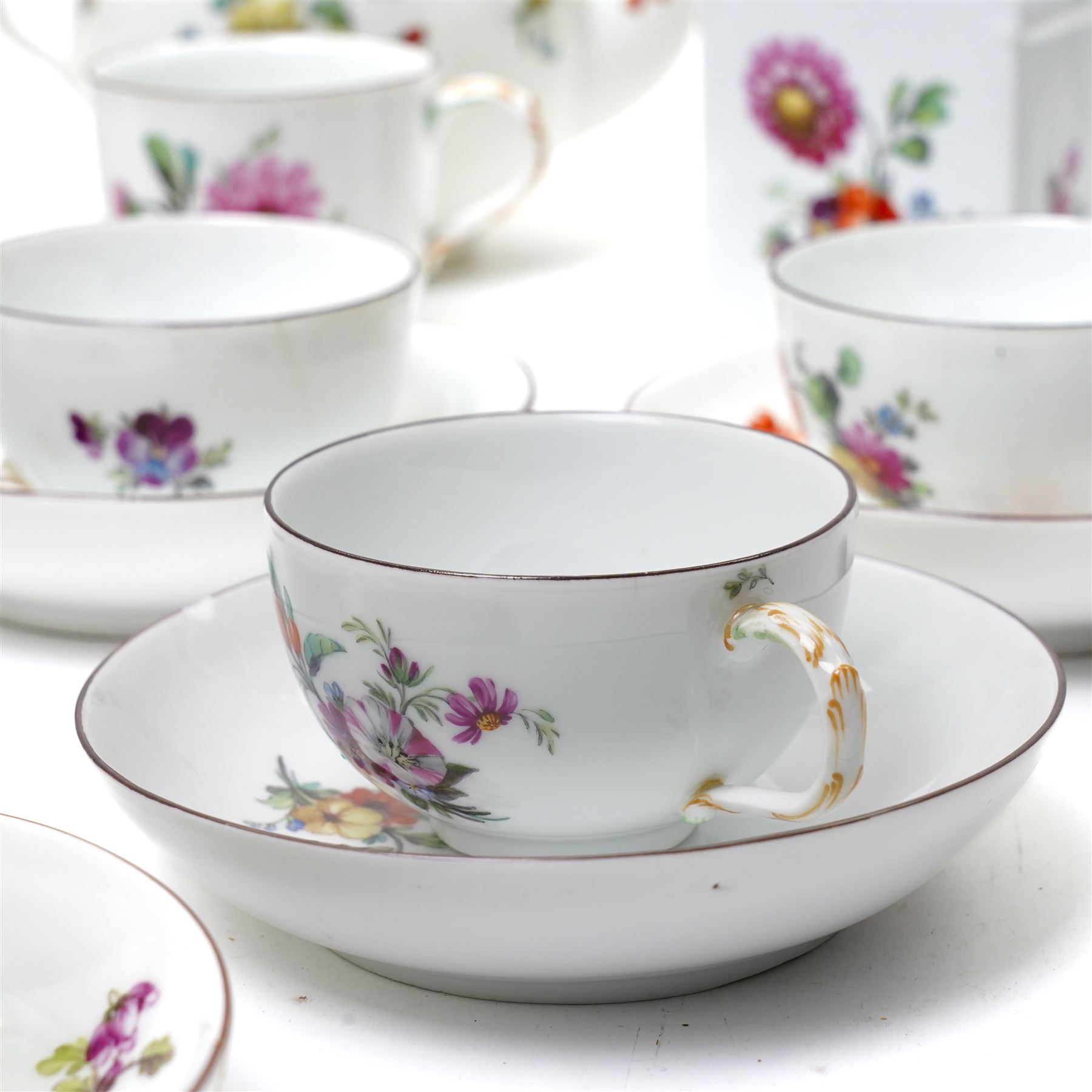 18th century Berlin part tea and coffee service circa 1780 painted with sprays of Spring flowers comprising four tea cups, five coffee cups,  six saucers, tea pot, tea caddy and sucrier and cover  