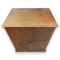 20th century oak Arts and Crafts fitted collector's cabinet, twin panelled doors with metal door pulls, enclosing a fitted interior, on a moulded plinth base