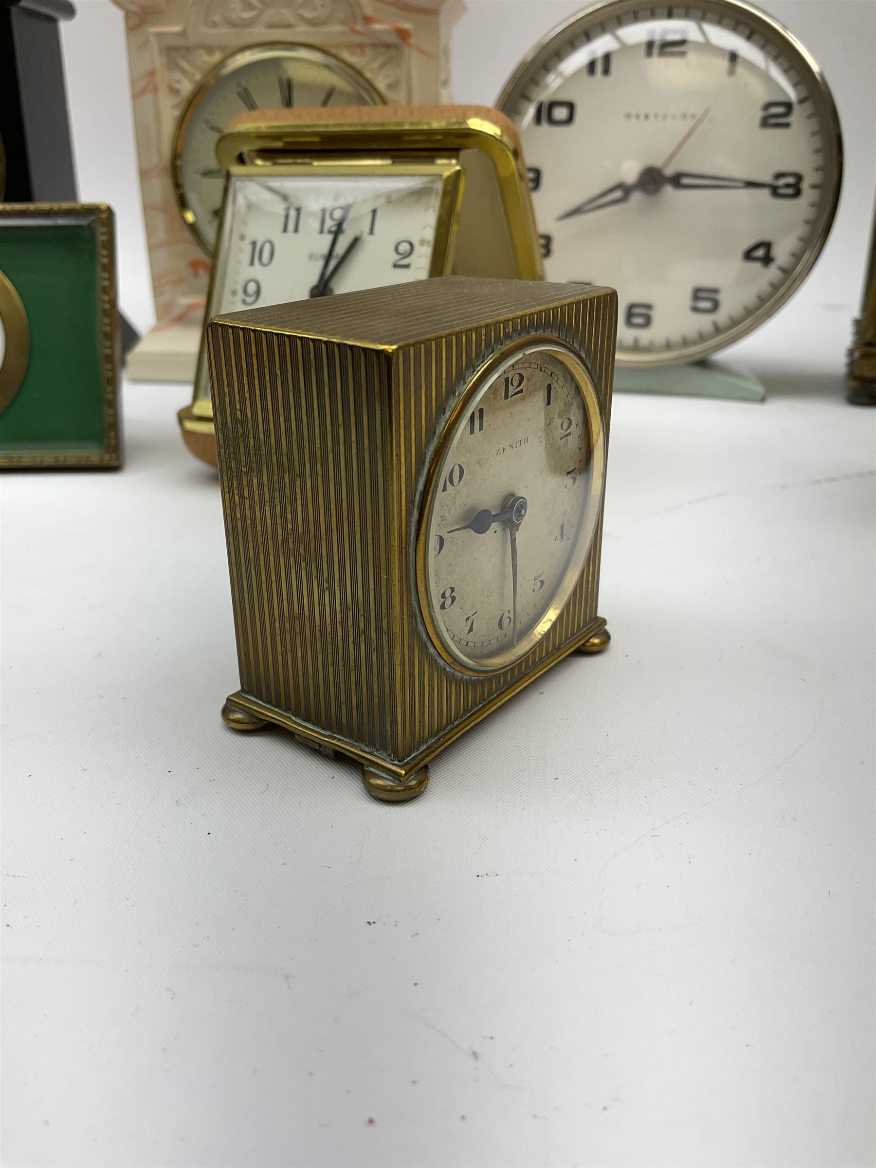 Miniature 'Zenith' travel alarm clock, in engine turned brass case with silvered numerical chapter ring, H5cm, together with other clocks to include Aynsley Portland Ware mantel clock, with moulded peacock design, Europa travelling clock, brass carriage clock, German copper clock of cube form etc