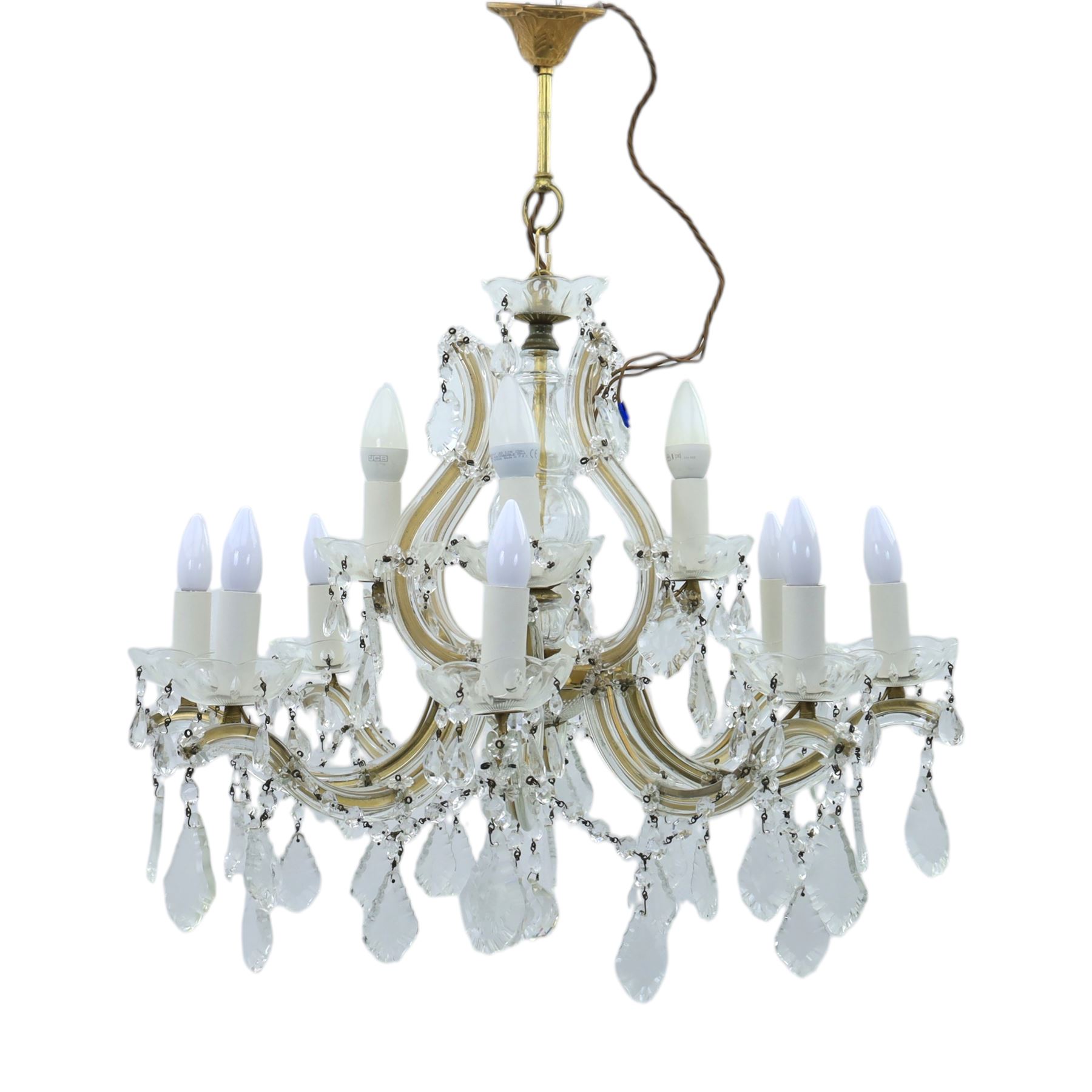 20th century Maria Theresa style twelve branch chandelier, gilt metal frame with scrolling arms clad in moulded glass, the central baluster stem issuing twelve candle sconces with glass drip pans, hung with faceted pendants and swags of cut glass beads 