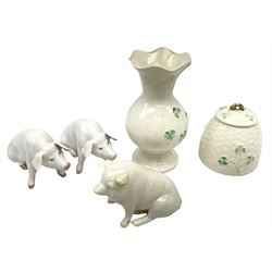 Two Royal Copenhagen figures modelled as seated pigs, Belleek figure of a pig with green mark beneath, and Belleek three leaf clover pattern vase and honey pot, all marked beneath (5)