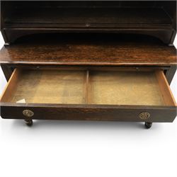 Early 20th century Jacobean Revival dark stained oak dresser, the associated upper section enclosed by twin glazed doors with shaped moulded glazing bars, over separate base fitted with two drawers, raised on bobbin turned legs