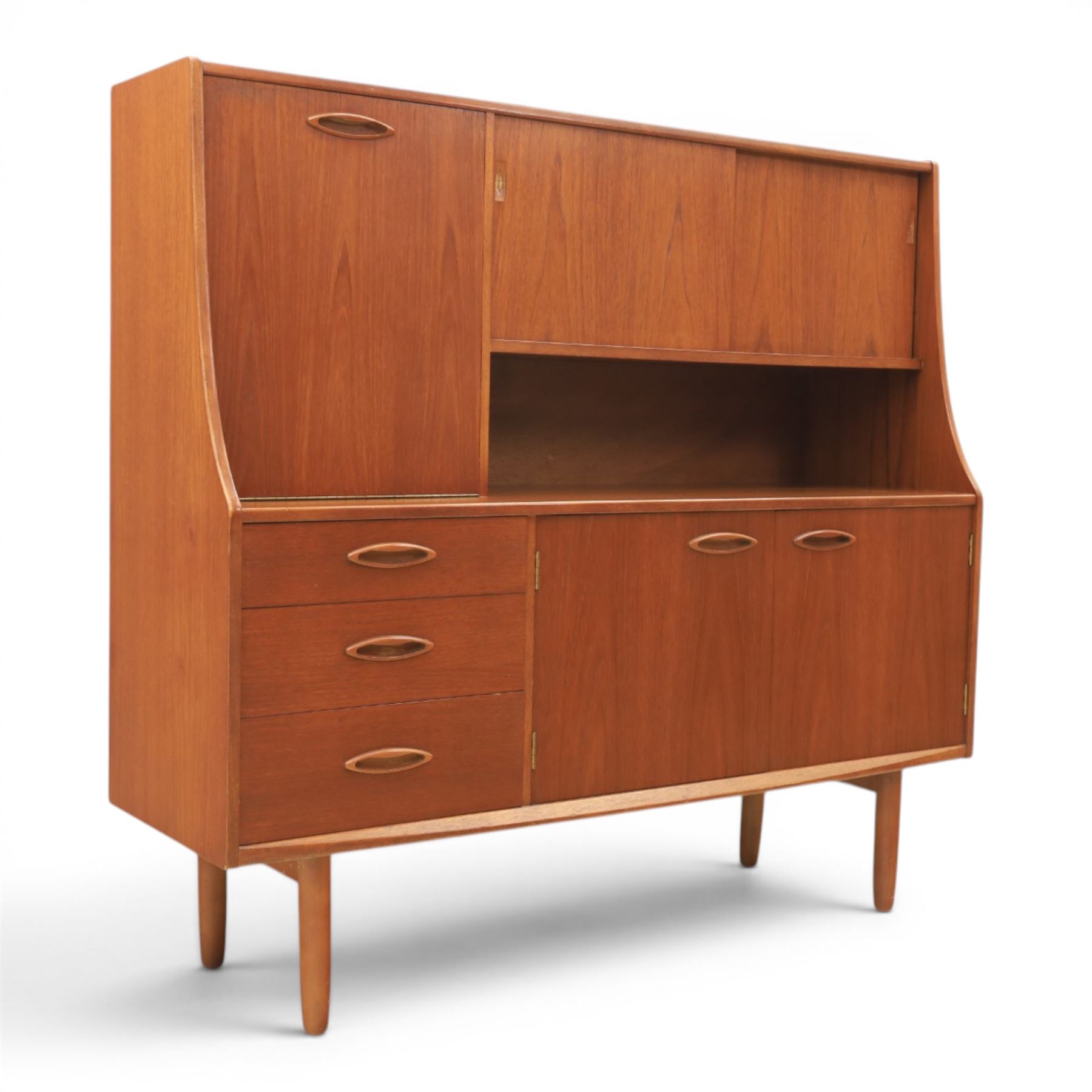 Jentique - mid-20th century teak highboard, fall front cabinet next to a sliding door cupboard above and open recess, the lower section with cabinet doors and three graduated drawers, raised on cylindrical legs