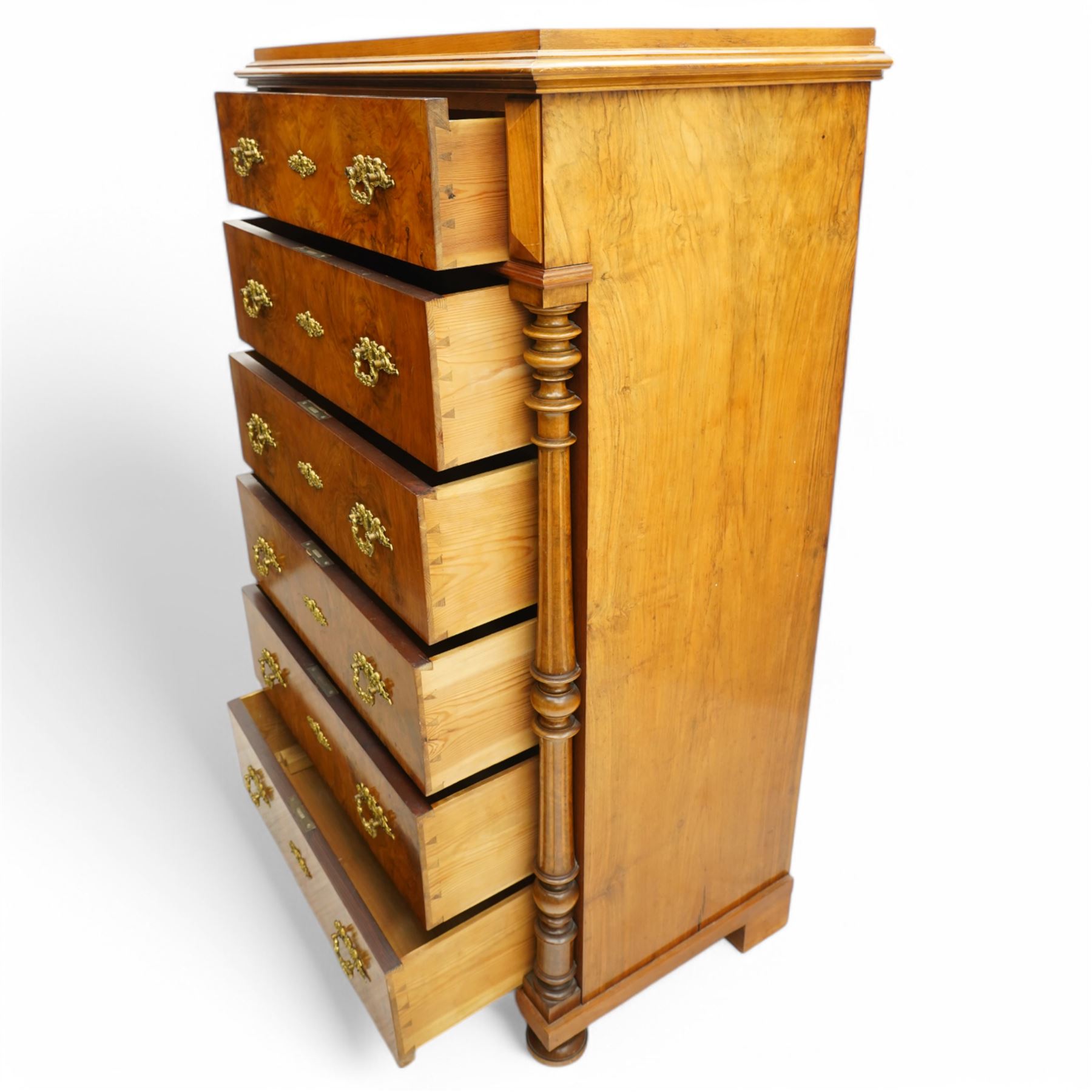 Tall late 19th century walnut chest, stepped and moulded top over six drawers, ornate cast gilt metal handles, enclosed by turned and fluted upright columns, on turned front feet 