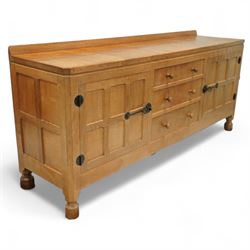 Mouseman - oak sideboard rectangular adzed top with raised back over three central drawers and two flanking cupboards, enclosed by panelled doors with wrought metal fixtures, the canted upright carved with mouse signature, on octagonal feet, by the workshop of Robert Thompson, Kilburn
