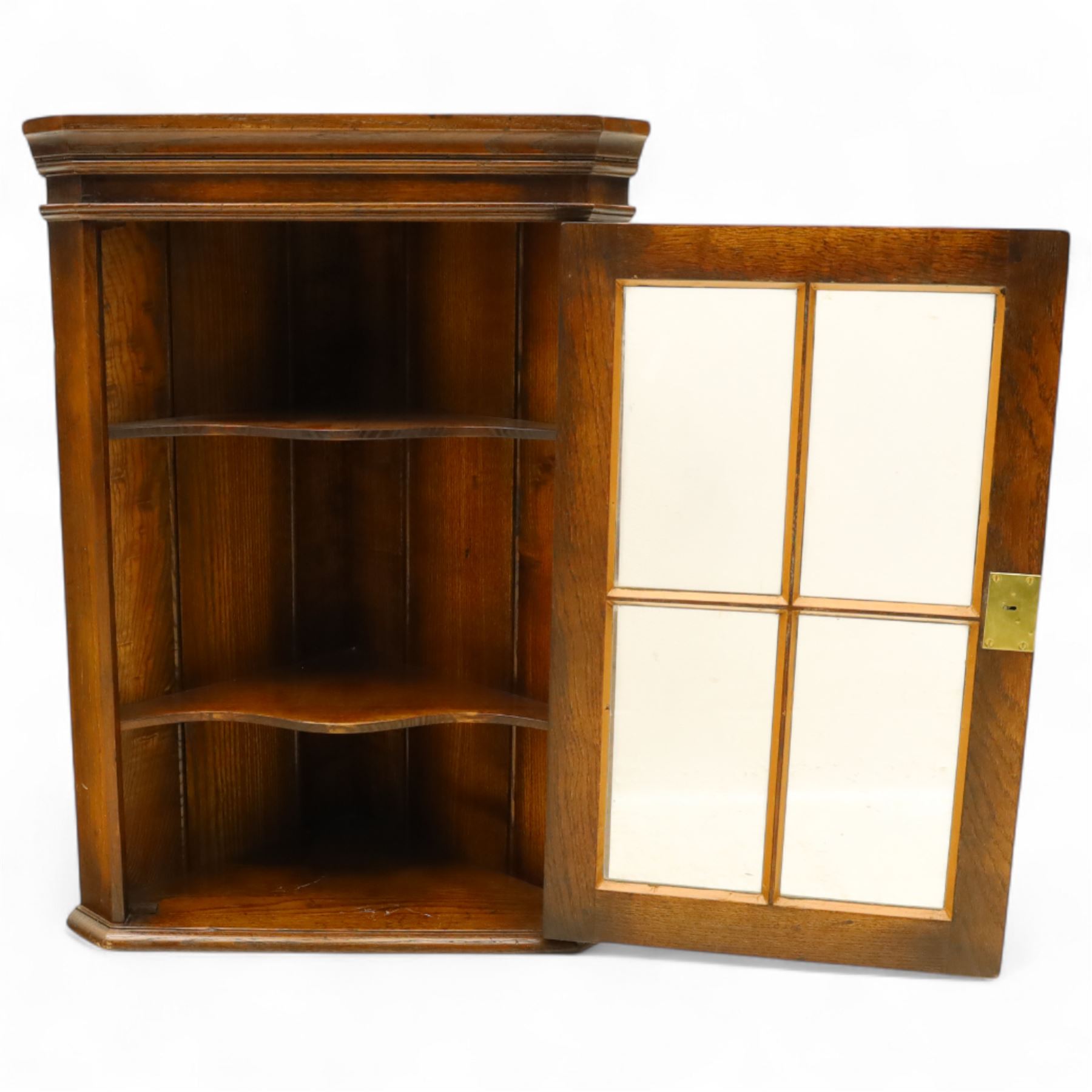 Early 20th century oak wall-mounted corner cabinet, moulded cornice above a single glazed door with six-panel astragal glazing, fitted interior with two shaped shelves