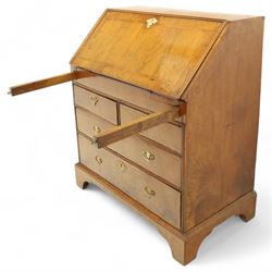 18th century walnut and herringbone banded bureau, the fall front enclosing a stepped and arched interior fitted with pigeonholes, drawers and concealed compartments, green tooled leather writing surface, over two short and three long graduated drawers with brass escutcheons and bail handles, shaped bracket feet