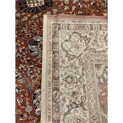 Persian design carpet, rust ground field decorated with large stylised plant motifs surrounded by smaller floral motifs, repeating trailing border
