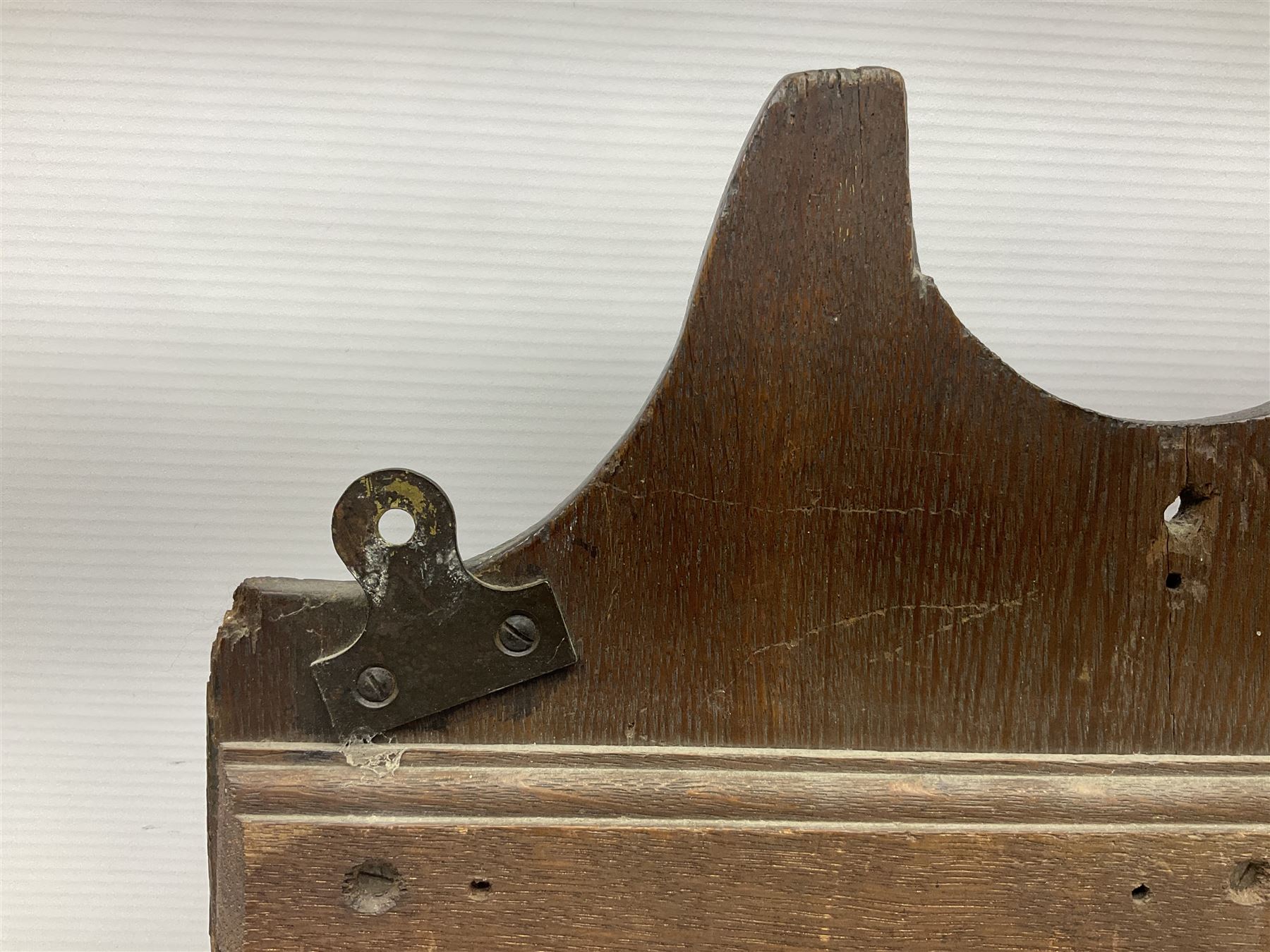 George III oak spoon rack and candle box, the rectangular backplate with shaped  pediment and two six aperture spoon racks, above a candlebox with hinged cover, with various brass spoons and a pair of brass candle snuffers, H56.5cm, W35cm, D14cm 