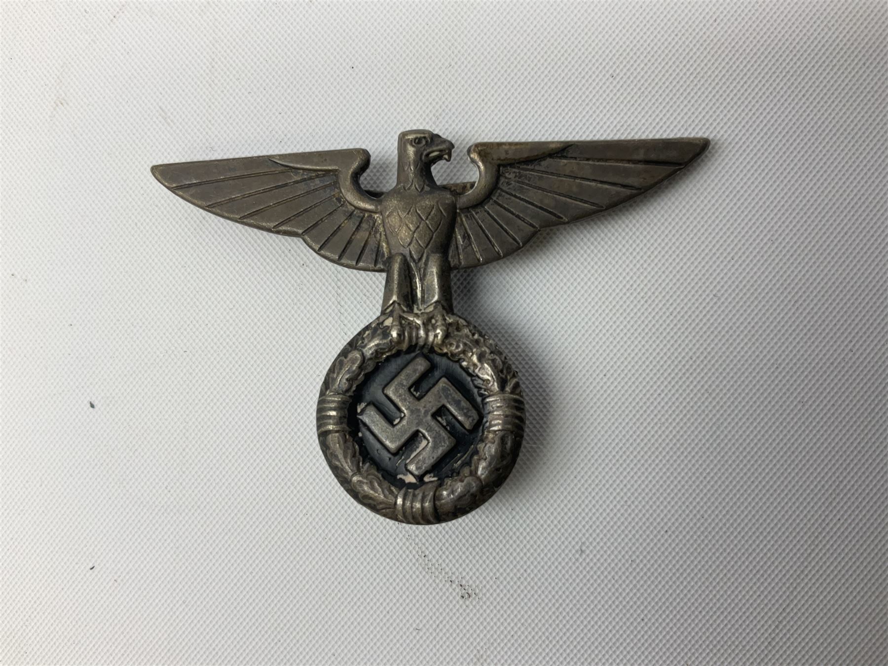 Three WW2 German visor cap badges comprising Police eagle, Political leaders eagle and Norwegian Quisling Party; all with fixings; and WW2 Polish visor cap badge (4)