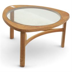 Mid-20th century teak and glass coffee table, of triangular form with rounded corners, inset circular glass top over curved stretcher base